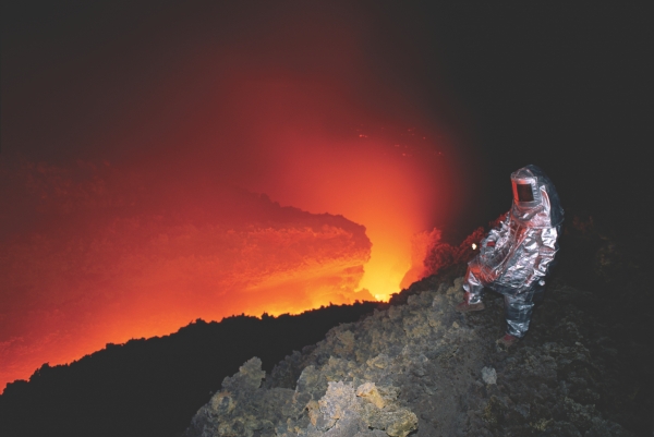 화산학자는 분출하는 화산 근처로 다가가 용암의 흐름을 연구한다.
